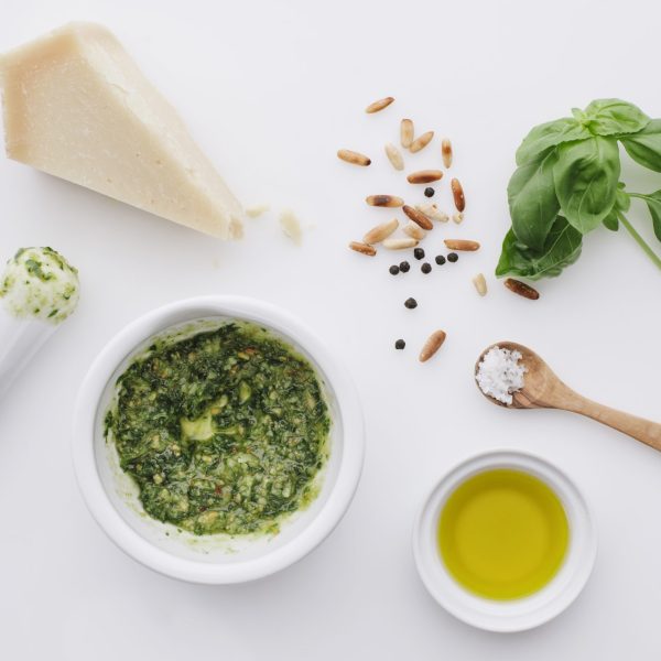 Zutaten für Pesto mit Mörser, Parmesan, Basilikum, geröstete Pinienkerne,Pfeffer, Oliveöl, Salz