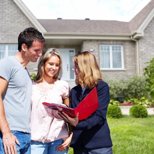 Real Estate agent woman near new house. Home for sale concept.
